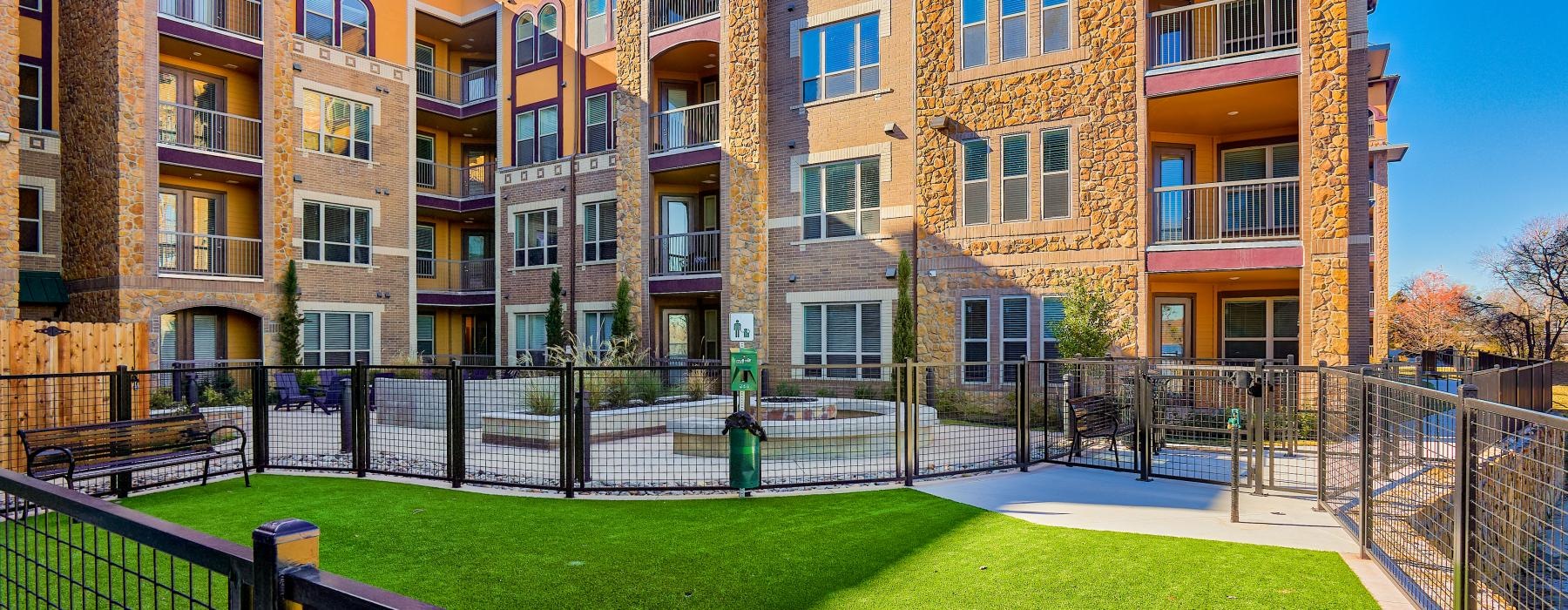a building with a fenced in dog park in front
