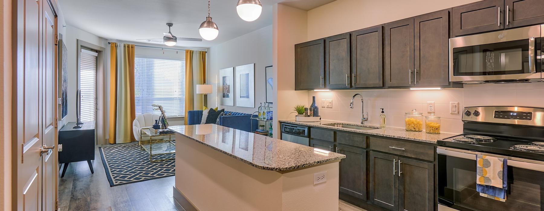 a kitchen with a marble island and dark cabinets