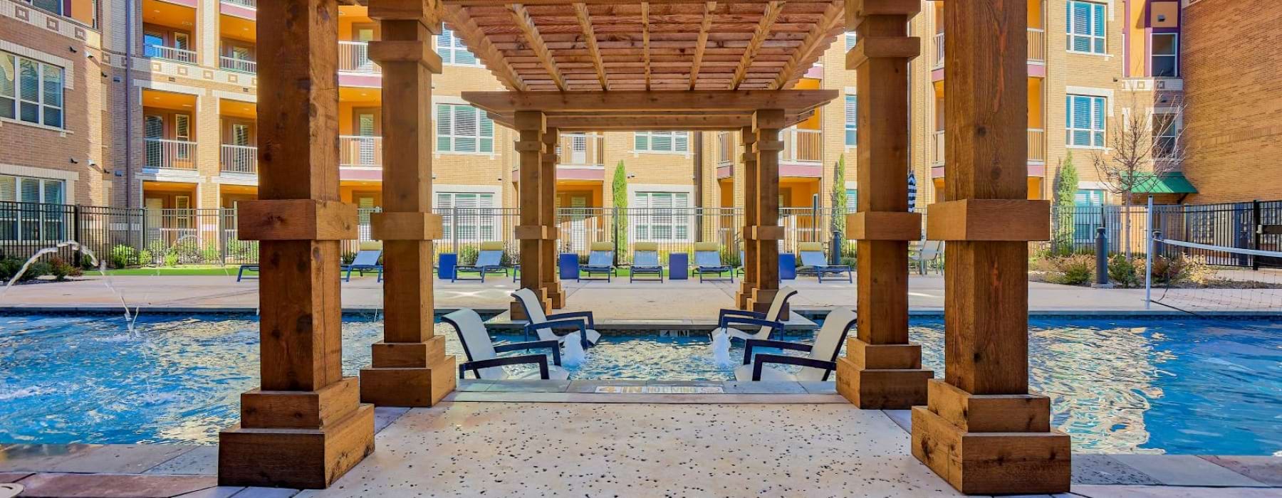 a wooden gazebo with a pool in the background