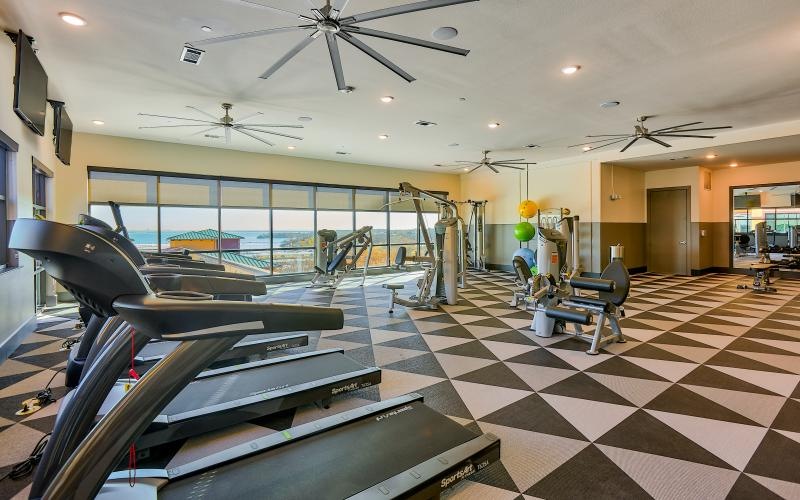 State-of-the-art amenities a gym with treadmills and a large window